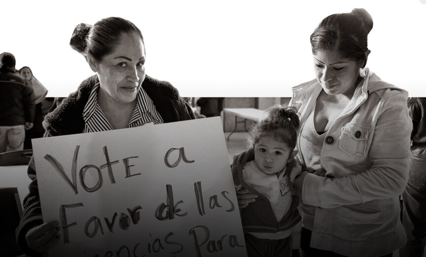 Mother and child standing next to woman holding a "vote" sign